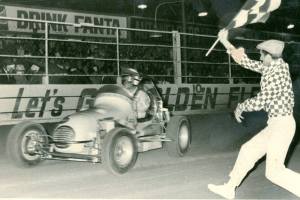 Photo thanks to 'Down Memory Lane With Noel O'Connor'. Driver Bob Wente takes the chequered flag at Rowley Park Speedway. And is that a young Glen Dix
