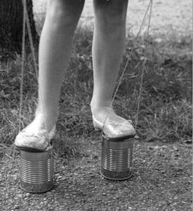 Photo from Google Images. A length of thin rope attached to the same cans would turn them into a pair of stilts. 