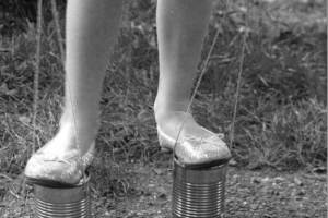 Photo from Google Images. A length of thin rope attached to the same cans would turn them into a pair of stilts. 